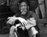 Local people in China during WWII: An elderly man sitting. During WWII.