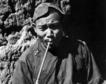 Local people in China: Village man smokes modest pipe, during WWII.