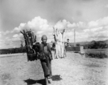 Man shouldering firewood in Yunnan during WWII.