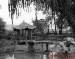Local scene in Yunnan province, China: A small pavillion over a dried pond in a Chinese town.