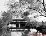 Local scenery in Yunnan province, China, during WWII: A covered pedestrian bridge over a canal.  From the collection of Eugene T. Wozniak.