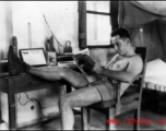 David Firman reads a magazine in his quarters in China during WWII.   From the collection of David Firman, 61st Air Service Group.