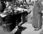 Local people get a tasty breakfast at a breakfast stand at a market somewhere in China during WWII.  Hickey.