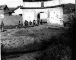 A village gate in a style once typical of Yunnan and Guizhou province, with a saying "Mountains Lofty and Clouds Deep" (“岭峻云深”) written above the gate. During WWII.  Photo from George Pollock.