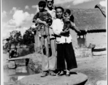 T/5 C. W. Leipnitz and a Chinese family pose together is a small village near Kunming, China, during WWII.