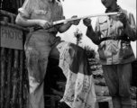 An American GI and and Chinese soldier examine Japanese flag and sword. During WWII in the CBI.