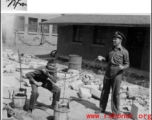 A GI tries out a carrying pole with two buckets in China during WWII.