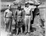 Two GIs (M. J. Hollman and Chaplain J. Kelly) pose with a chinese guard in SW China during WWII.