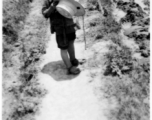 A small boy on a path amongst farm fields near Kunming, China, May 1945.