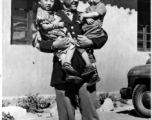 Chennault holds Tayng Wong and Toong Di, who had come with Col P. Y. Shu, interpreter, to present Chennault Christmas greetings written by grade school children. During WWII.