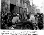 Capt. Grove campaigning for himself for mayor in a small town we passed through, from atop his jeep. Croughan on left, Capt. Penick on right.  Near an American base in Guangxi province (either Guilin or Liuzhou), China, during WWII.