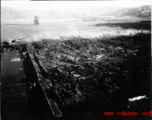 Smoke arises from city wall after attack by B-25 Mitchell bombers during battle with Japanese ground forces, flying over Tengchung (Tengchong), near the China-Burma border in far SW China.