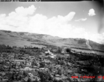 A explosion in Japanese-held Tengchong, probably from a bomb dropped by B-25 Mitchell bombers during battle with Japanese ground forces, flying over Tengchung (Tengchong), near the China-Burma border in far SW China.