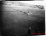 Image of a very odd explosion near Tengch0ng--out in the  middle of a rice paddy. What this a bomb blast or an aircraft crash? Image taken from B-25 Mitchell bombers during battle with Japanese ground forces, flying near Tengchung (Tengchong), near the China-Burma border in far SW China.