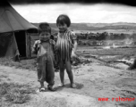 A boy and girl playing in Yunnan, China, near an American air base. During WWII.