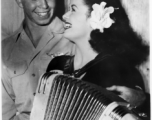 Celebrities visit and perform at Yangkai, Yunnan province, during WWII: Ruth Dennis poses with the accordion and a happy GI.