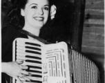 Celebrities visit and perform at Yangkai, Yunnan province, during WWII: Ruth Dennis poses with the accordion.