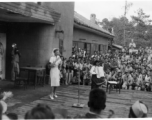 Celebrities (including Ann Sheridan in this shot) perform on an outdoor stage set up at the "Last Resort" at Yangkai, Yunnan province, during WWII. Notice both Americans and Chinese in the audience for this USO event.