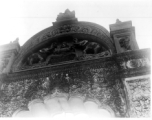 Ornate carved arch doorway, likely as part of a temple complex.  Scenes in India witnessed by American GIs during WWII. For many Americans of that era, with their limited experience traveling, the everyday sights and sounds overseas were new, intriguing, and photo worthy.