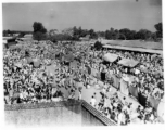 Expansive and busy market crowded with people.  Scenes in India witnessed by American GIs during WWII. For many Americans of that era, with their limited experience traveling, the everyday sights and sounds overseas were new, intriguing, and photo worthy.