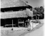 Local kids hang out at a thatched-roofed building advertising "Watch Maker."  Scenes in India witnessed by American GIs during WWII. For many Americans of that era, with their limited experience traveling, the everyday sights and sounds overseas were new, intriguing, and photo worthy.