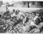 Women doing something with baskets.  Scenes in India witnessed by American GIs during WWII. For many Americans of that era, with their limited experience traveling, the everyday sights and sounds overseas were new, intriguing, and photo worthy.